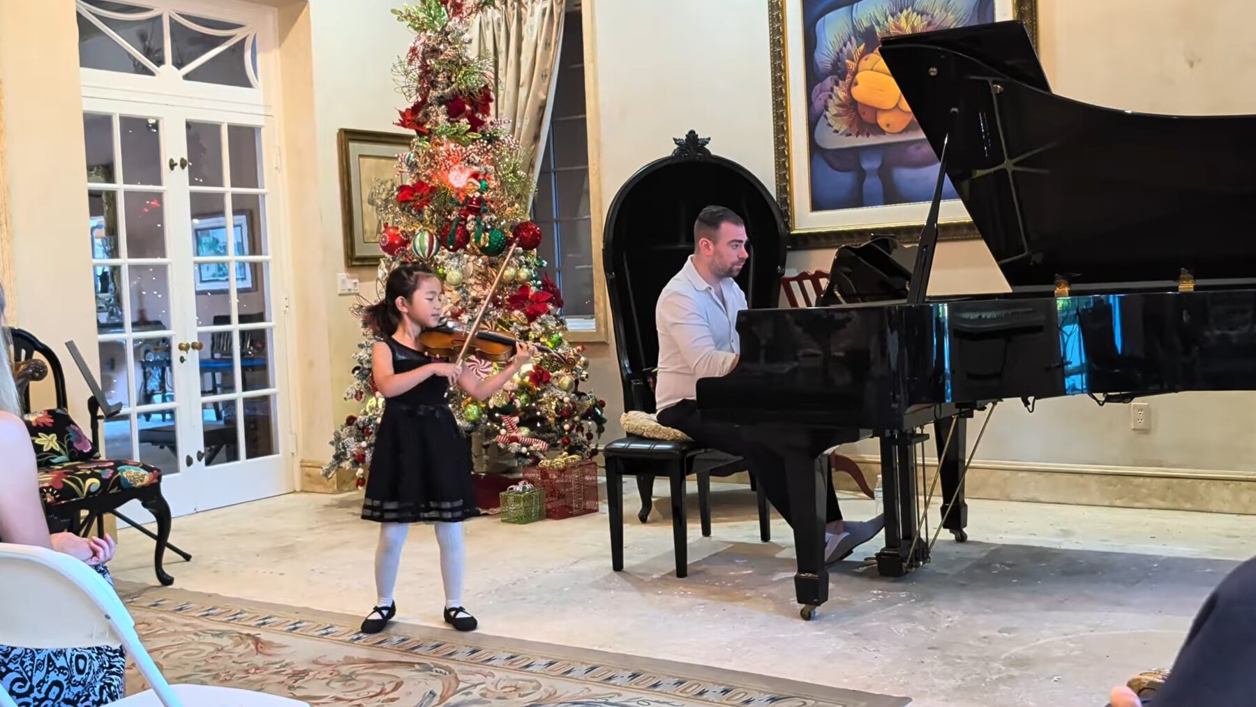 Hailey Murata performing violin at a holiday recital with piano accompaniment